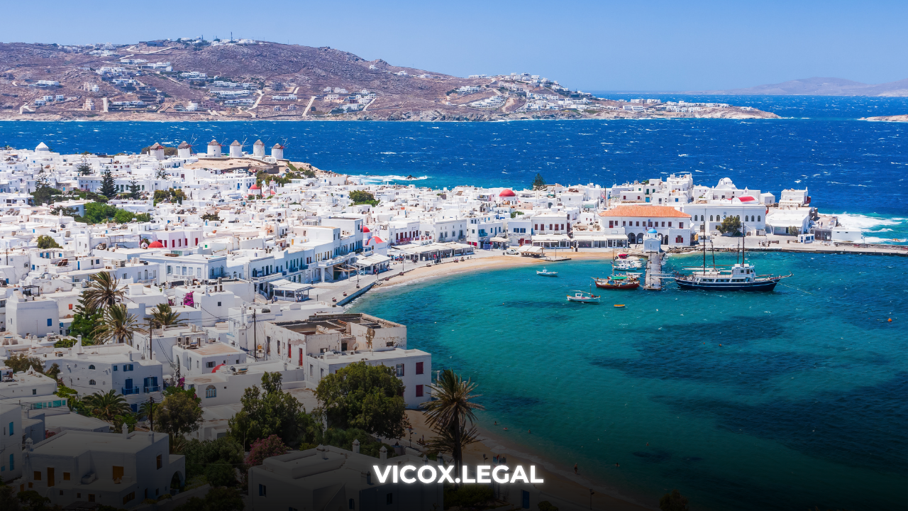 Aerial view of Mykonos harbor in Greece with whitewashed houses and turquoise sea – cover image for buying real estate in Greece with crypto.