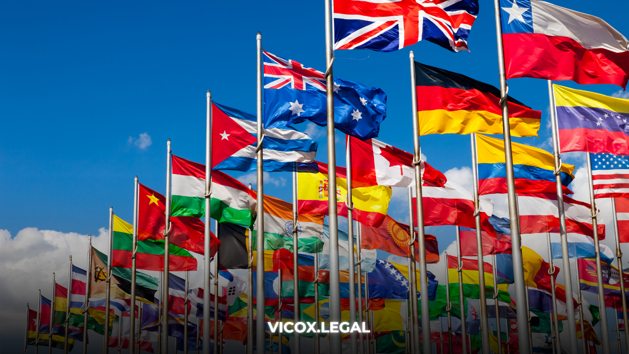 Multiple international flags representing countries where buying real estate with crypto can grant residency, including Spain, Dubai, Greece, Portugal, USA, and Oman.