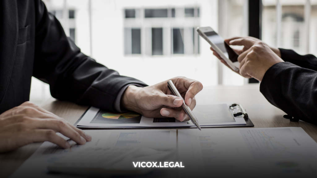 Lawyers reviewing crypto real estate compliance documents during a client meeting.
